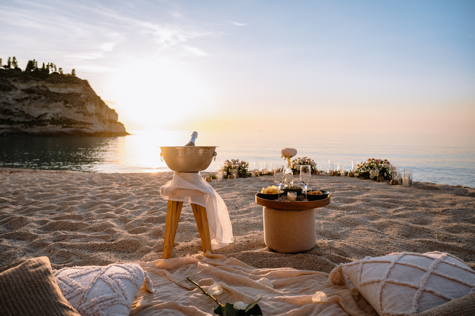Luxury setup for beach proposal in Tropea, champagne bottle, flowers, glasses