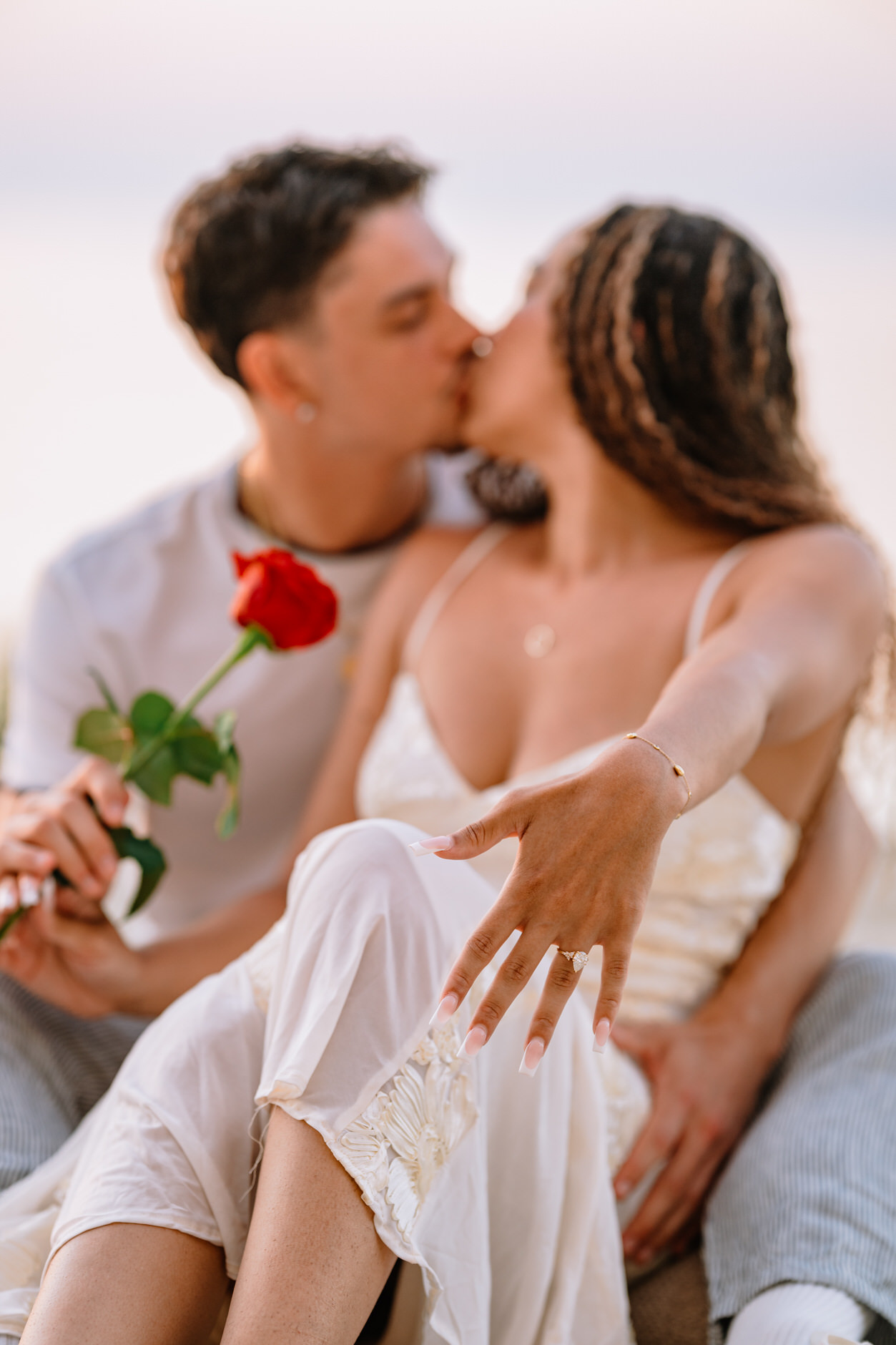 Detail shot of an engagement ring with the calm sea of Tropea in the background