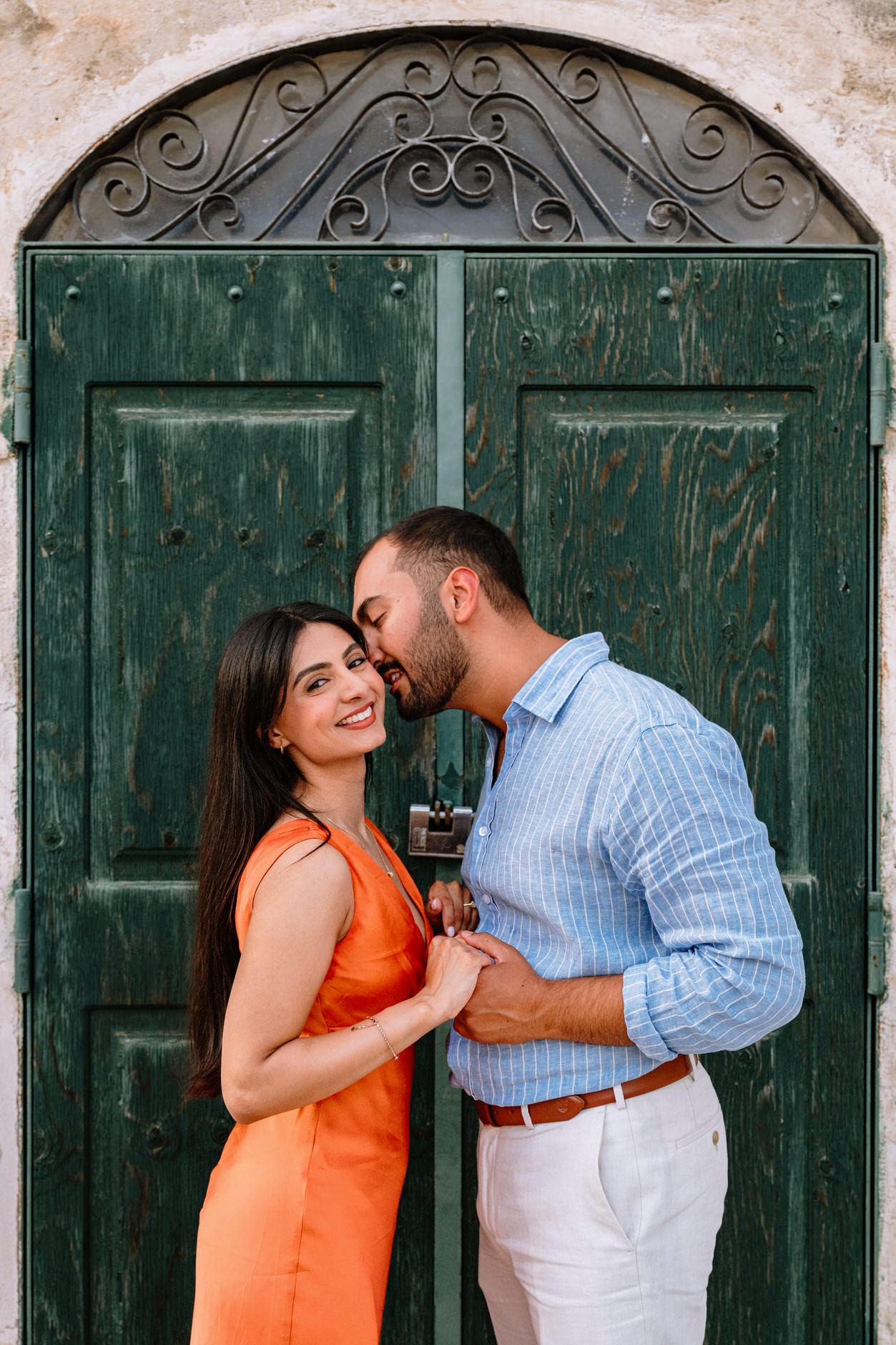 couple kissing in front of the famous green door of matera