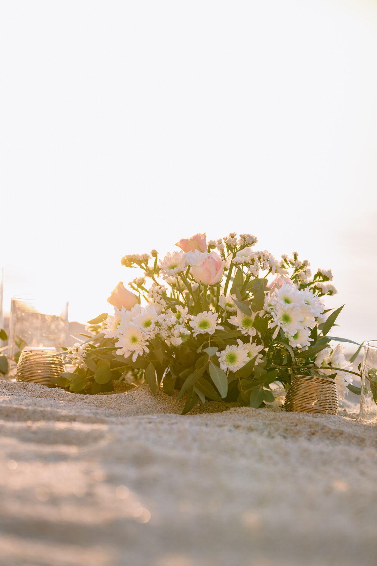 Close up of flowers and luxury picnic setup on the sand in Tropea