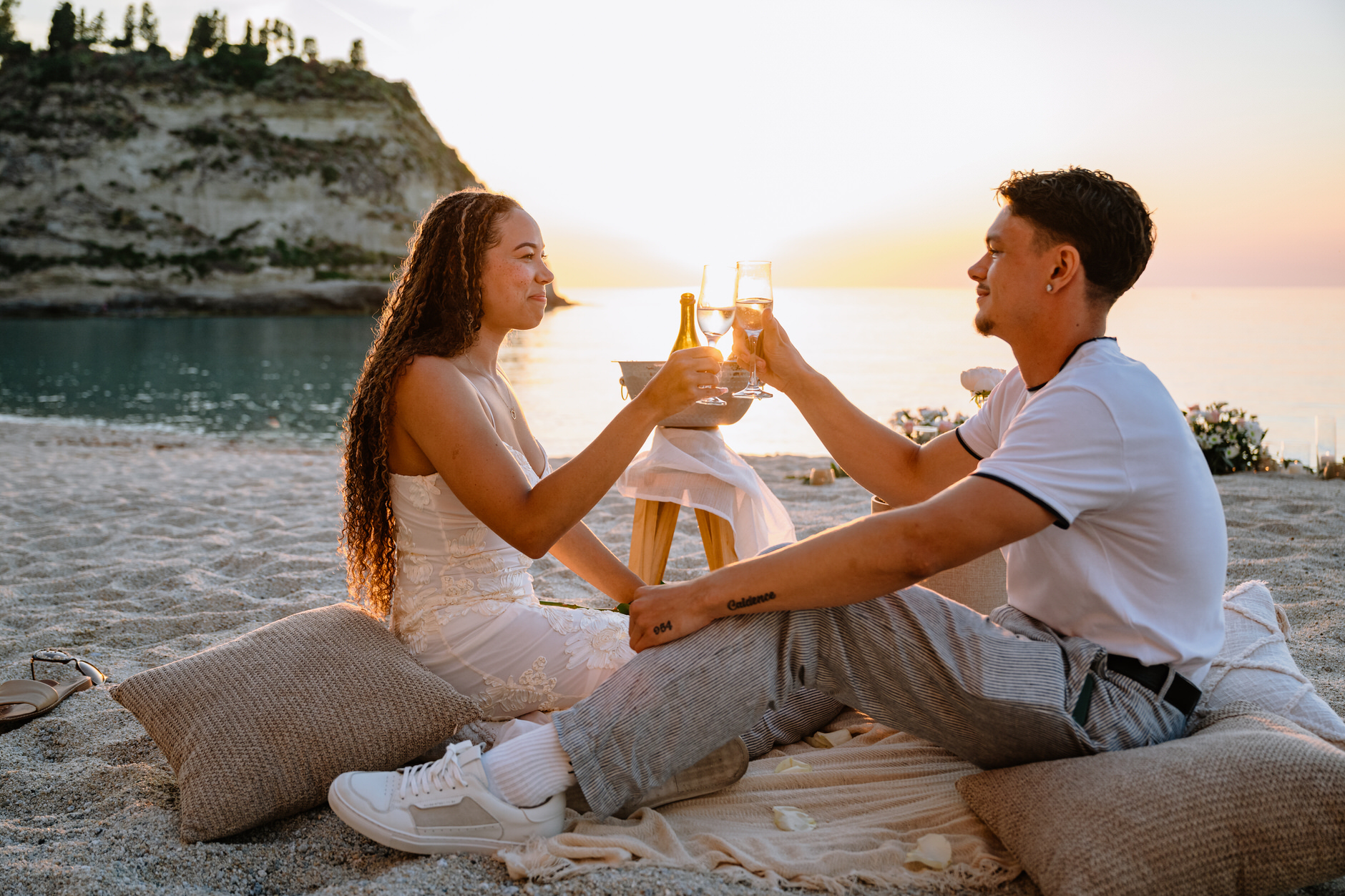 Engaged couple enjoying the sunset together after a successful beach proposal in Tropea